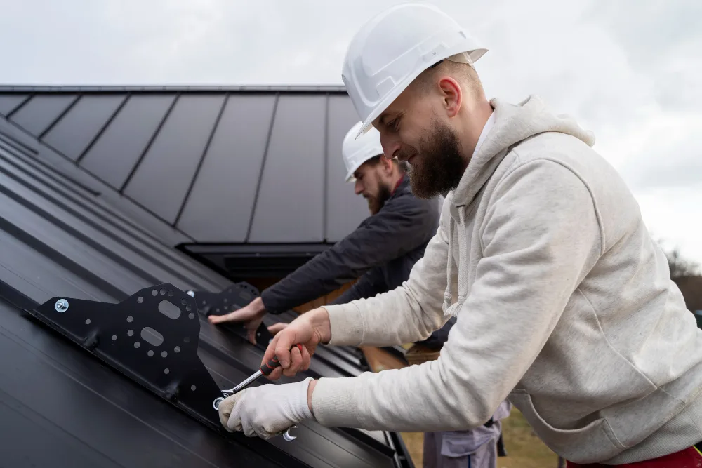 Roofing contractors installing a standing seam metal roof on a Michigan home