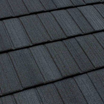 Close-up texture of dark charcoal stone-coated steel shingle roofing
