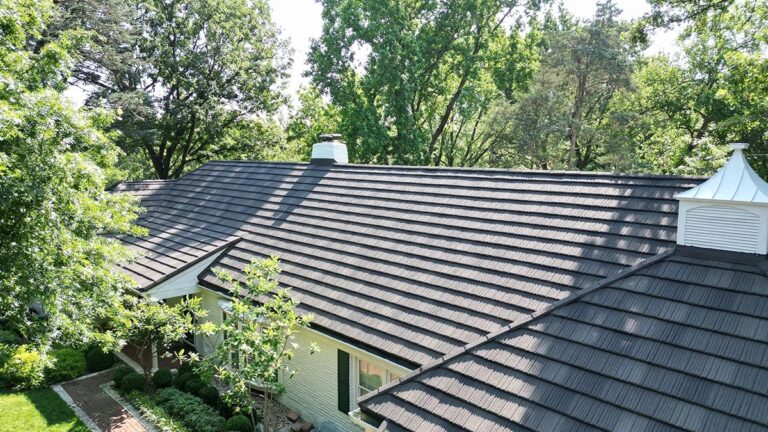 Dark charcoal stone-coated steel shingle roof installed on a home, full view