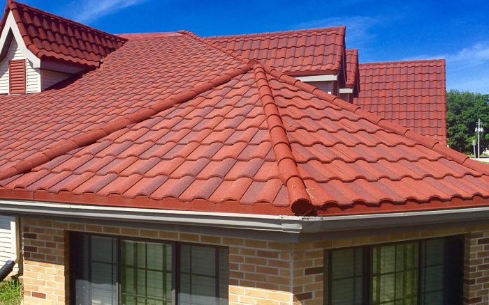 Red tile-style metal roof installed on a home, full view