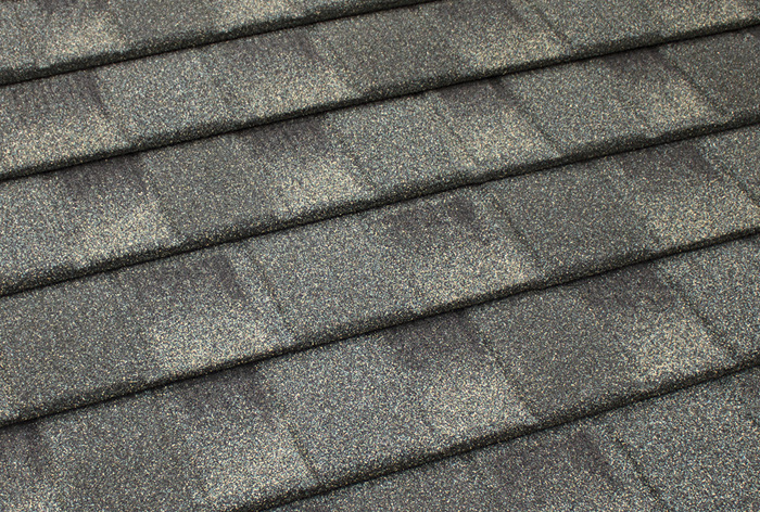 Close-up texture of gray-green stone-coated steel shake-style roofing